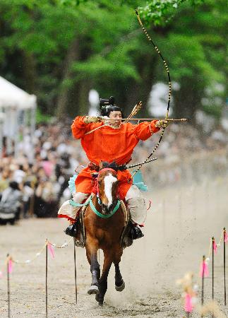 下鴨神社の「流鏑馬神事」で、疾走する馬上から矢を放つ射手＝３日午後、京都市