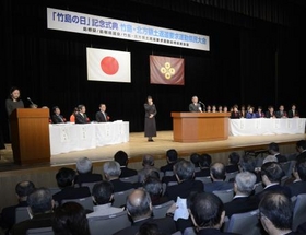 「竹島の日」式典の会場近くに集まり、韓国国旗を掲げ抗議する人たち ＝22日午後、松江市