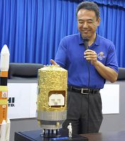 「こうのとり」の模型を示す古川さん（種子島宇宙センターで）